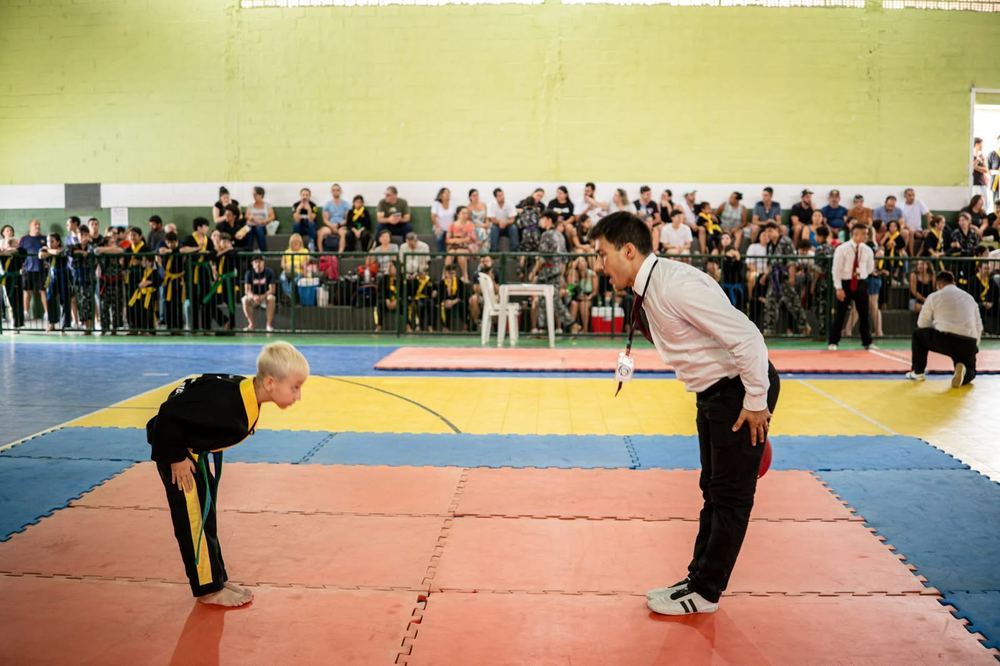 Criança fazendo reverência ao instrutor antes da luta em campeonato